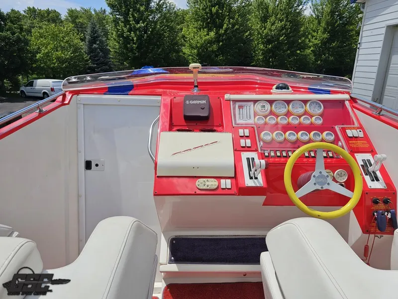 Slide: The Image of Interior of a 2004 Sonic USA 45SS boat with red dashboard and steering wheel. - 45