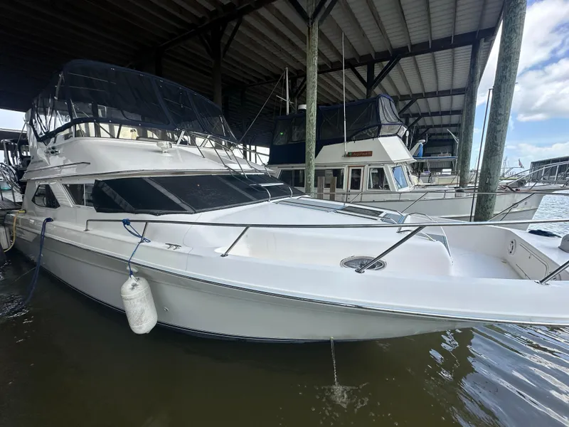 Slide: The Image of 1996 Sea Ray 440 Express Bridge yacht docked in a marina. - 10