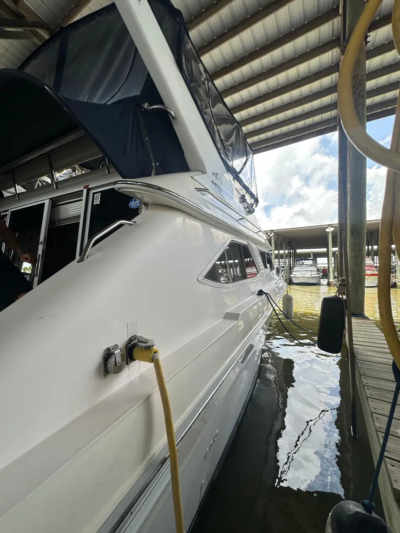 Slide: The Image of 1996 Sea Ray 440 Express Bridge yacht docked under a covered marina. - 14