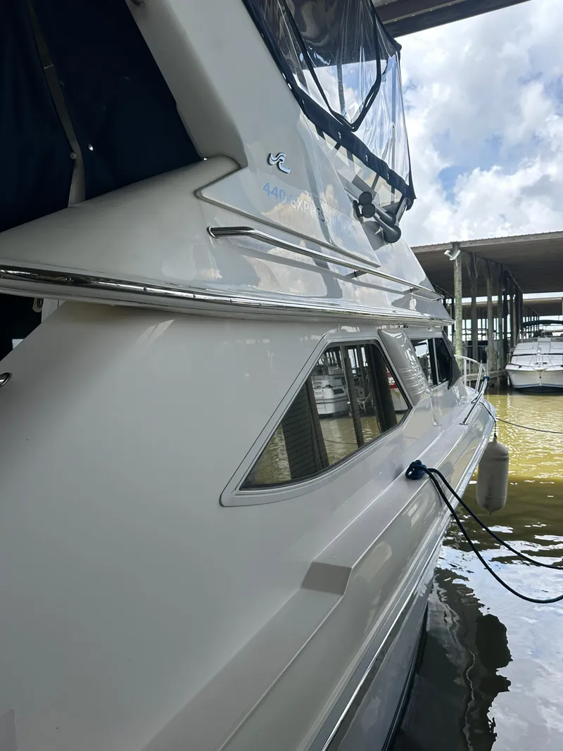 Slide: The Image of 1996 Sea Ray 440 Express Bridge yacht docked in marina, side view. - 15