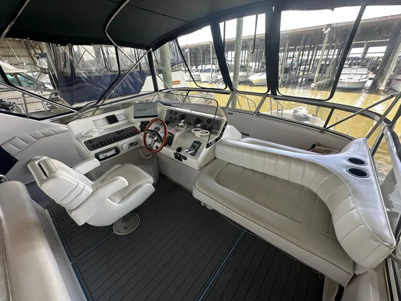Slide: The Image of 1996 Sea Ray 440 Express Bridge cockpit with steering wheel, seating, and control panel. - 18