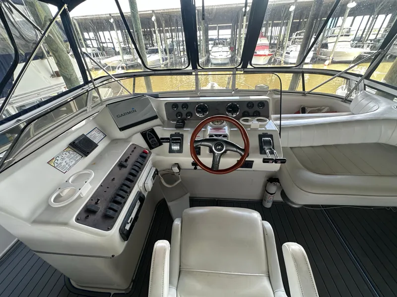 Slide: The Image of 1996 Sea Ray 440 Express Bridge helm with Garmin navigation, leather seating, and wood-accented steering wheel. - 19