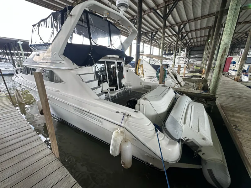 Slide: The Image of 1996 Sea Ray 440 Express Bridge yacht docked in a covered marina. - 2