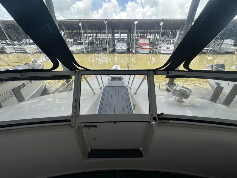 Slide: The Image of 1996 Sea Ray 440 Express Bridge yacht docked, viewed from the helm, with marina background. - 25