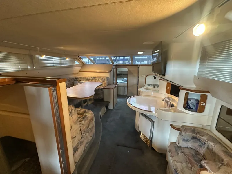 Slide: The Image of Interior of 1996 Sea Ray 440 Express Bridge yacht, featuring dining area and kitchenette. - 28