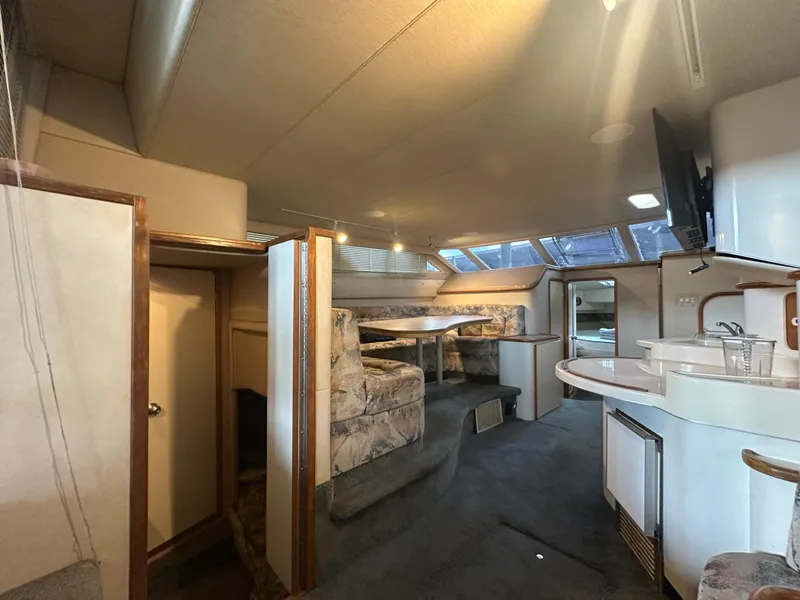Slide: The Image of Interior of 1996 Sea Ray 440 Express Bridge yacht with dining area and kitchenette. - 29