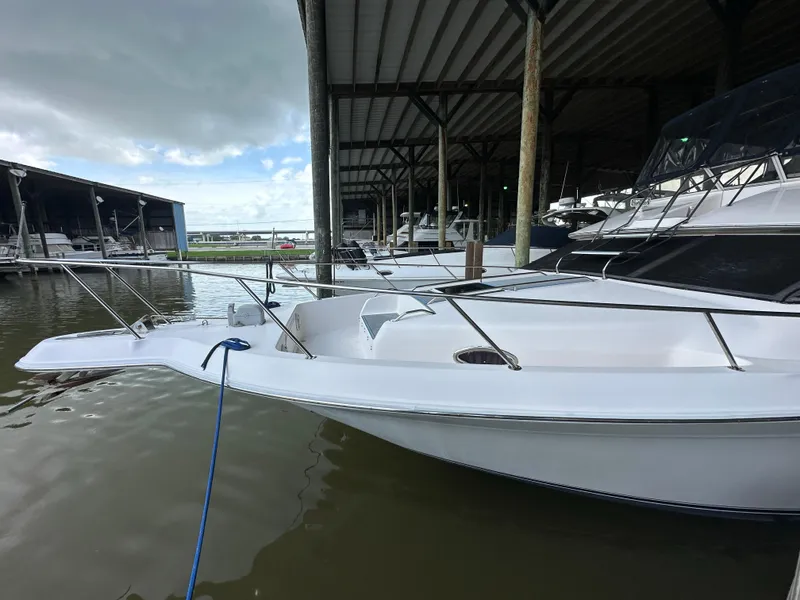 Slide: The Image of 1996 Sea Ray 440 Express Bridge docked in a marina under a covered shelter. - 3
