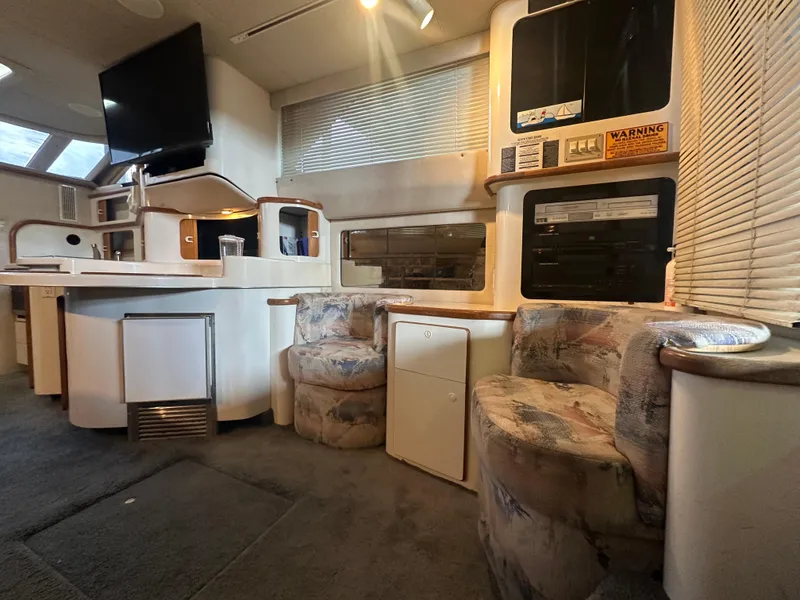Slide: The Image of Interior of 1996 Sea Ray 440 Express Bridge with cozy seating and modern amenities. - 30