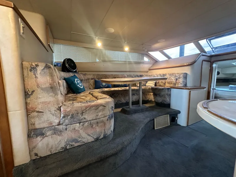 Slide: The Image of Interior of 1996 Sea Ray 440 Express Bridge with cozy seating and dining area. - 31