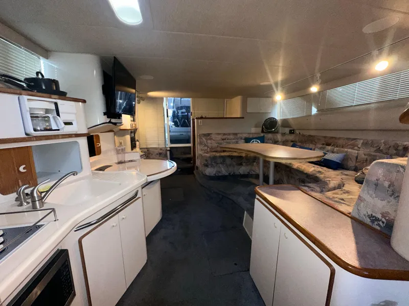 Slide: The Image of Interior of 1996 Sea Ray 440 Express Bridge yacht with kitchen and seating area. - 32