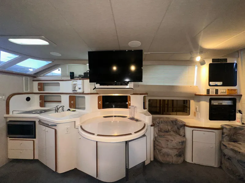 Slide: The Image of Interior of 1996 Sea Ray 440 Express Bridge with modern kitchen and seating area. - 34