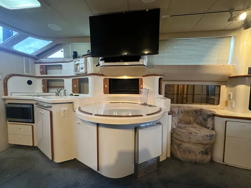 Slide: The Image of Interior of 1996 Sea Ray 440 Express Bridge yacht with modern kitchen and seating area. - 35
