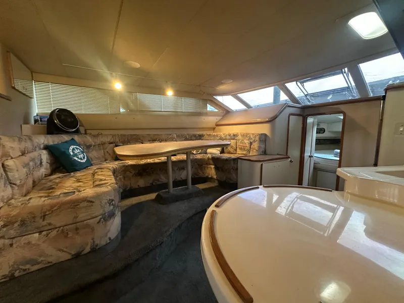 Slide: The Image of Interior of 1996 Sea Ray 440 Express Bridge with cozy seating and dining area. - 36
