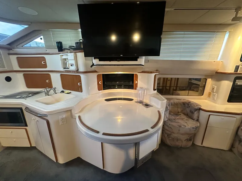 Slide: The Image of Interior of 1996 Sea Ray 440 Express Bridge with modern kitchen and seating area. - 37