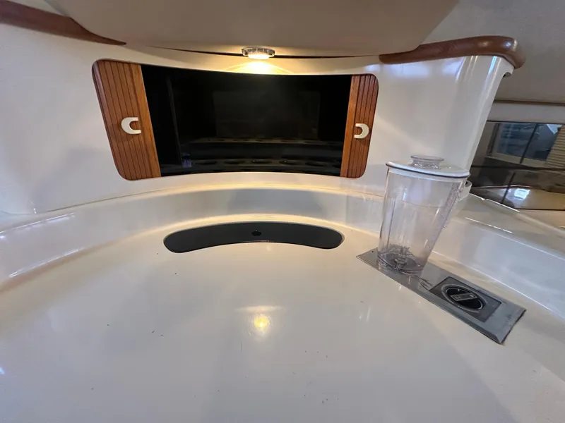 Slide: The Image of Interior of 1996 Sea Ray 440 Express Bridge with sink and storage area. - 38