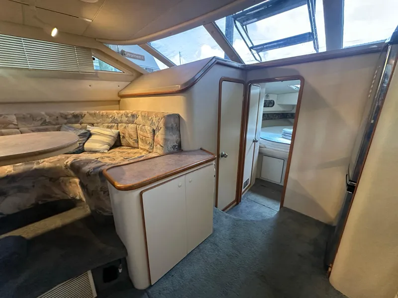 Slide: The Image of Interior of 1996 Sea Ray 440 Express Bridge, featuring cozy seating and natural light. - 39