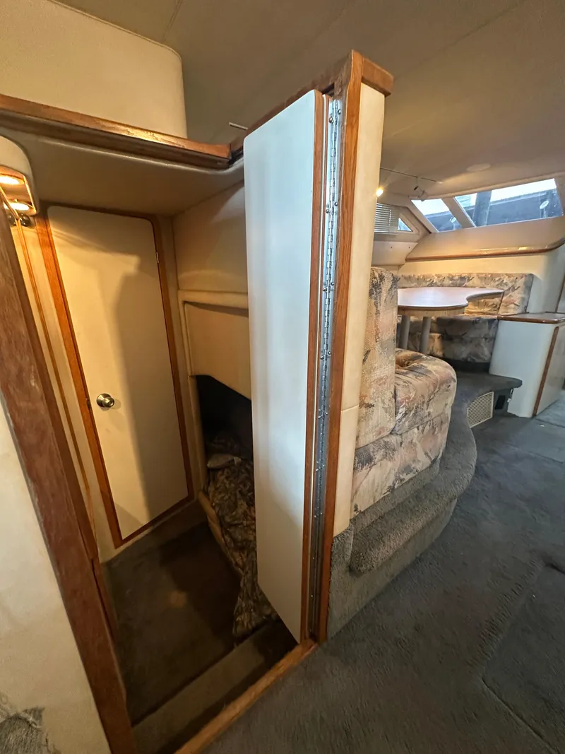 Slide: The Image of Interior of 1996 Sea Ray 440 Express Bridge with cozy seating and wooden accents. - 40