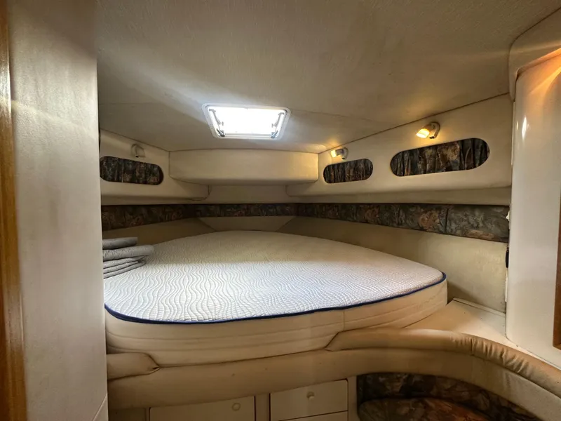 Slide: The Image of 1996 Sea Ray 440 Express Bridge cabin interior with bed and lighting. - 42