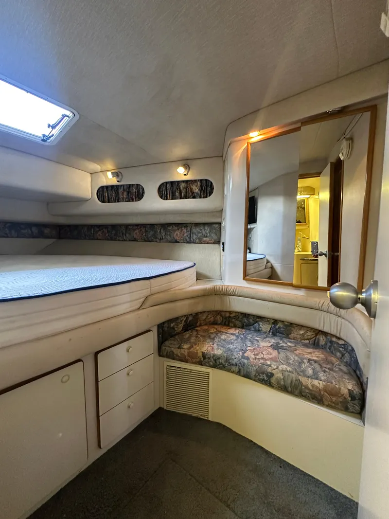 Slide: The Image of 1996 Sea Ray 440 Express Bridge cabin interior with bed, seating, and storage. - 44