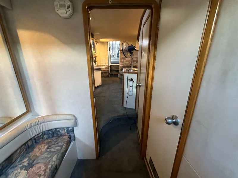Slide: The Image of Interior of 1996 Sea Ray 440 Express Bridge, featuring seating and hallway view. - 45