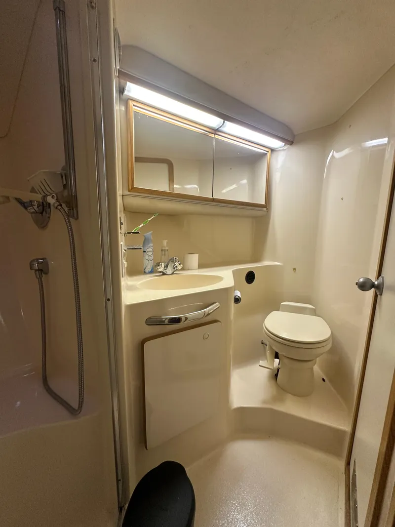 Slide: The Image of 1996 Sea Ray 440 Express Bridge bathroom with shower, sink, and toilet. - 47