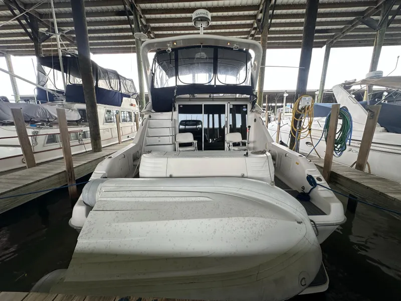 Slide: The Image of 1996 Sea Ray 440 Express Bridge docked with inflatable boat on stern. - 6