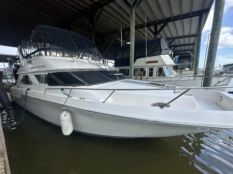 Slide: The Image of 1996 Sea Ray 440 Express Bridge yacht docked under a covered marina. - 8