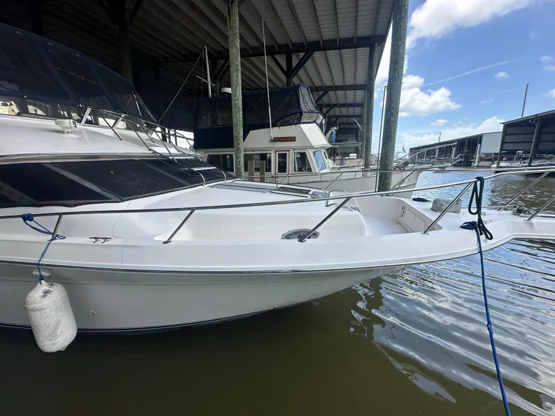 Slide: The Image of 1996 Sea Ray 440 Express Bridge docked under a covered marina. - 9