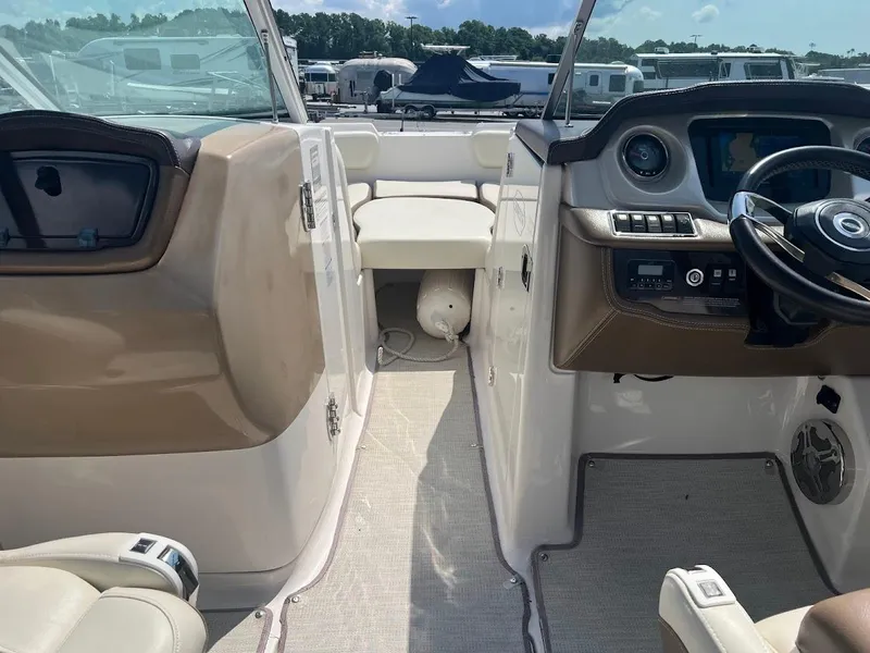 Slide: The Image of 2017 Chaparral 244 Sunesta boat interior with steering wheel and seating area. - 2