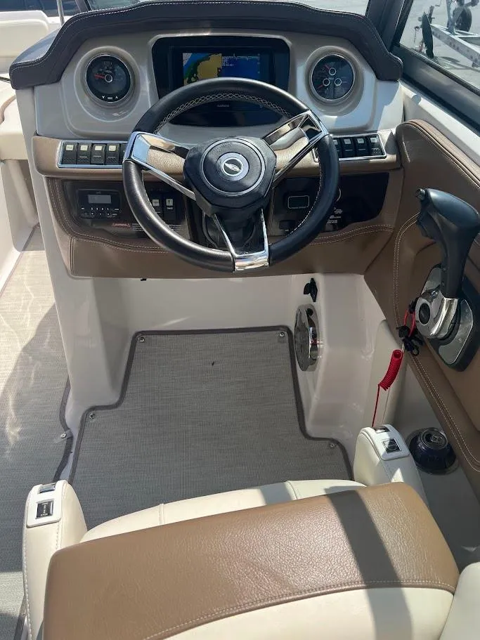 Slide: The Image of 2017 Chaparral 244 Sunesta boat dashboard with steering wheel and control panel. - 5