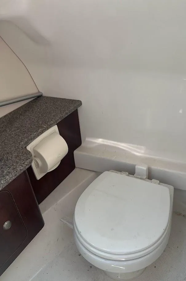 Slide: The Image of 2017 Chaparral 244 Sunesta boat bathroom with toilet and granite countertop. - 8
