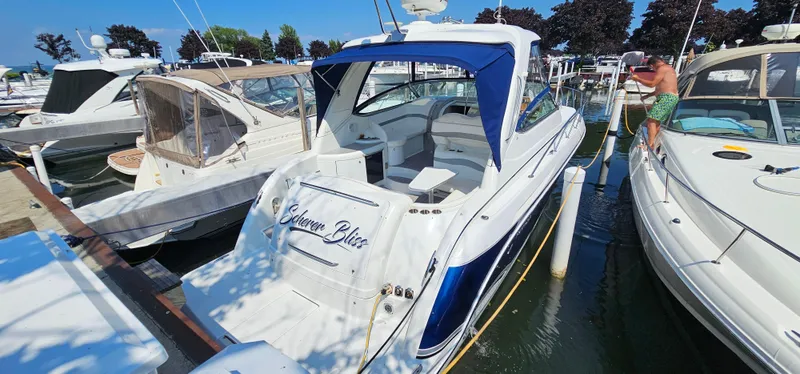 Slide: The Image of A white and blue motor yacht docked in a busy marina. A man stands on a nearby boat. - 9