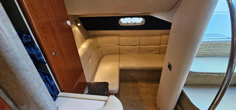 Slide: The Image of The 2007 Formula 37 Performance Cruiser cabin features an L-shaped leather couch and a porthole. - 49