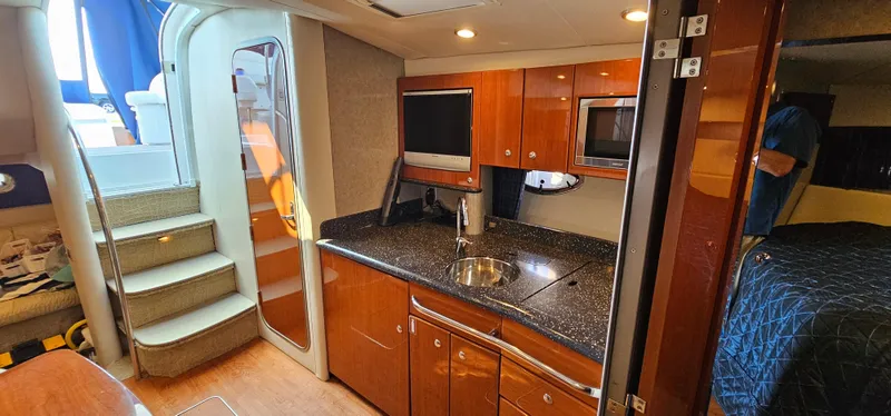 Slide: The Image of Interior of a 2007 Formula 37 Performance Cruiser featuring a sleek kitchen, stairs, and cozy sleeping area. - 40