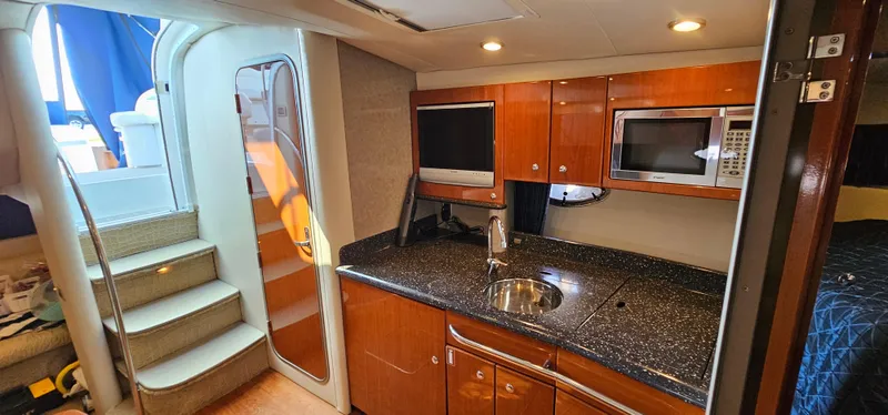 Slide: The Image of The 2007 Formula 37 Performance Cruiser's galley features wood cabinets, a sink, and a microwave. - 39