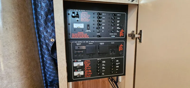Slide: The Image of Electrical control panel inside a boat with various switches and indicators. - 48