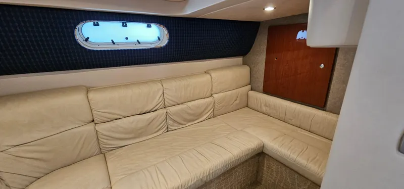 Slide: The Image of Interior of a 2007 Formula 37 Performance Cruiser with beige leather sofa and porthole. - 50
