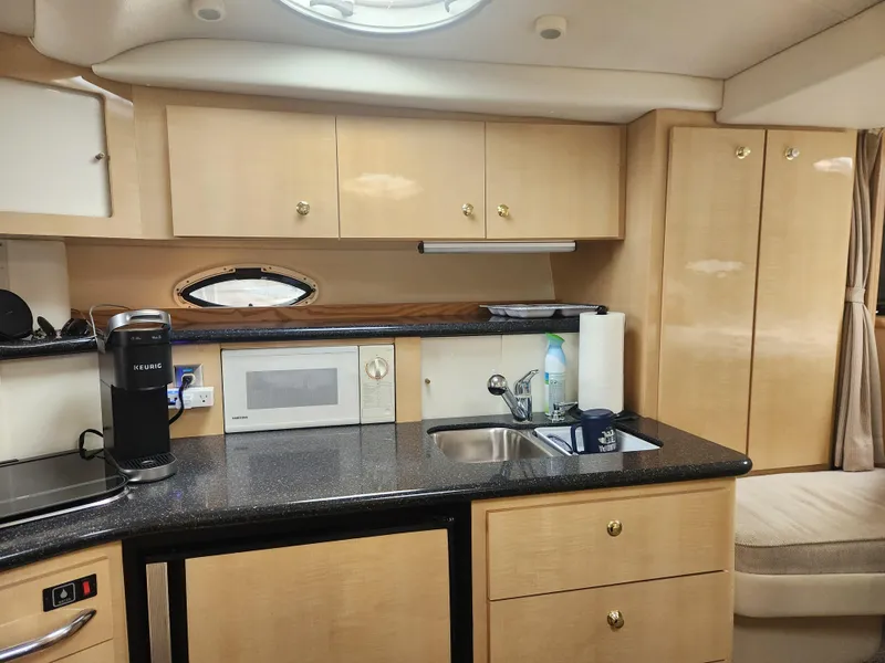 Slide: The Image of 2001 Maxum 3300 SCR yacht interior kitchen with cabinets, sink, microwave, and coffee maker. - 17