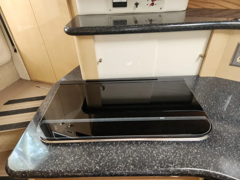 Slide: The Image of 2001 Maxum 3300 SCR yacht interior with sleek black countertop and modern appliances. - 18