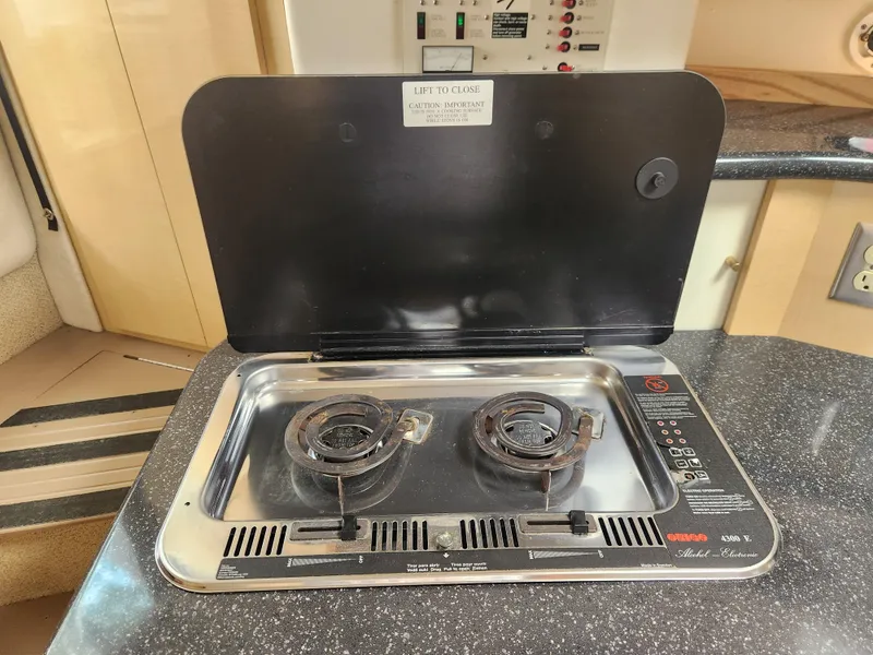 Slide: The Image of 2001 Maxum 3300 SCR boat stove with two burners and closed lid in cabin kitchen. - 19