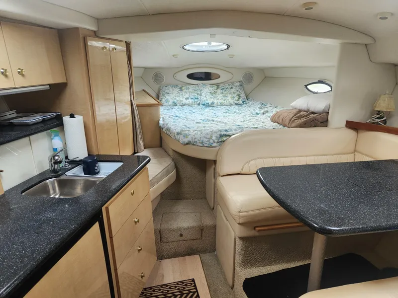 Slide: The Image of 2001 Maxum 3300 SCR cabin interior with kitchenette, dining area, and cozy sleeping quarters. - 21
