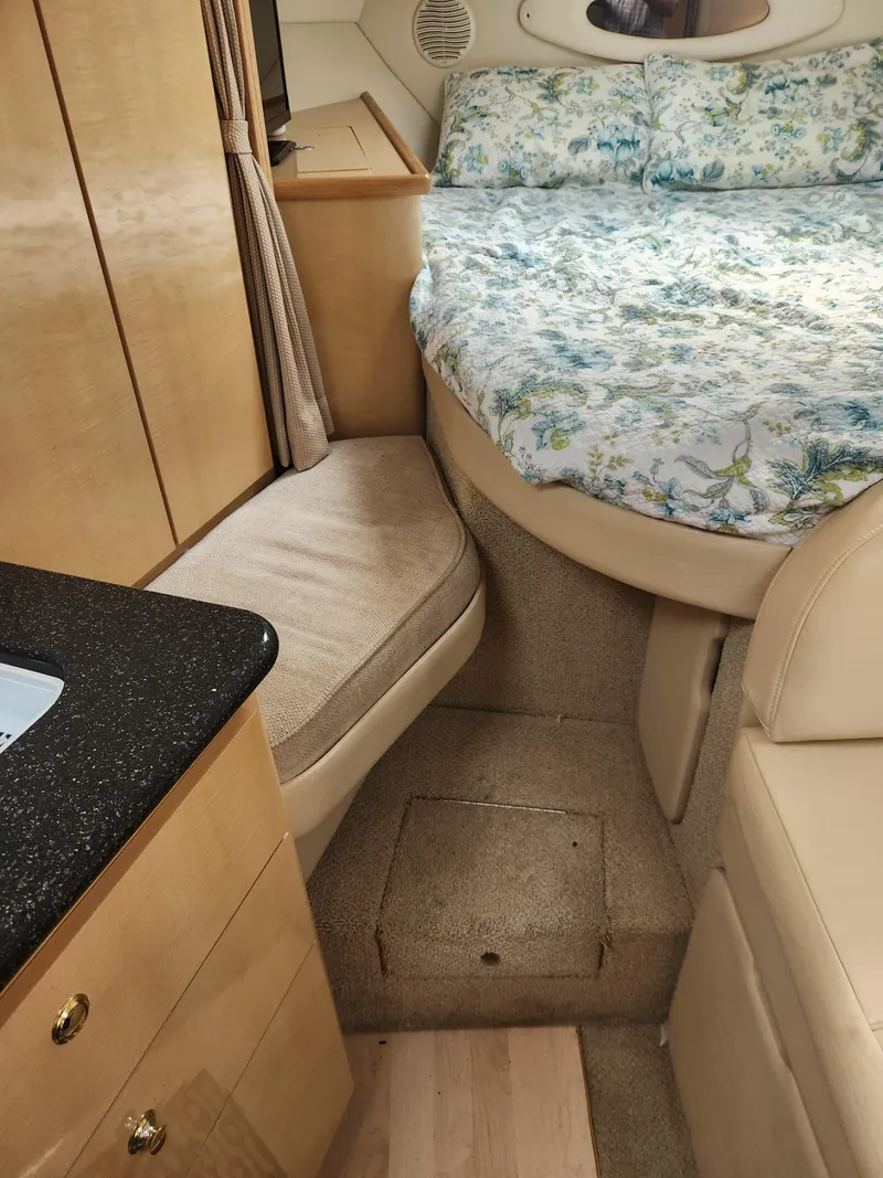 Slide: The Image of 2001 Maxum 3300 SCR cabin interior with bed, seating, and wooden cabinetry. - 23