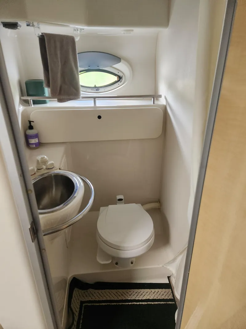 Slide: The Image of Compact bathroom in a 2001 Maxum 3300 SCR boat with sink and toilet. - 25