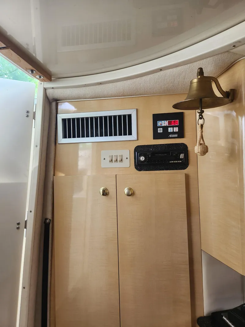 Slide: The Image of 2001 Maxum 3300 SCR cabin interior with control panel, air vent, and brass bell. - 28