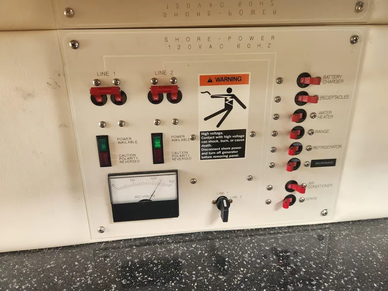 Slide: The Image of Electrical control panel on a 2001 Maxum 3300 SCR boat, featuring switches and warning label. - 30