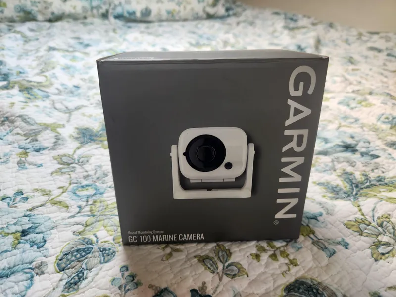 Slide: The Image of Garmin GC 100 Marine Camera box on floral-patterned bedspread. - 31