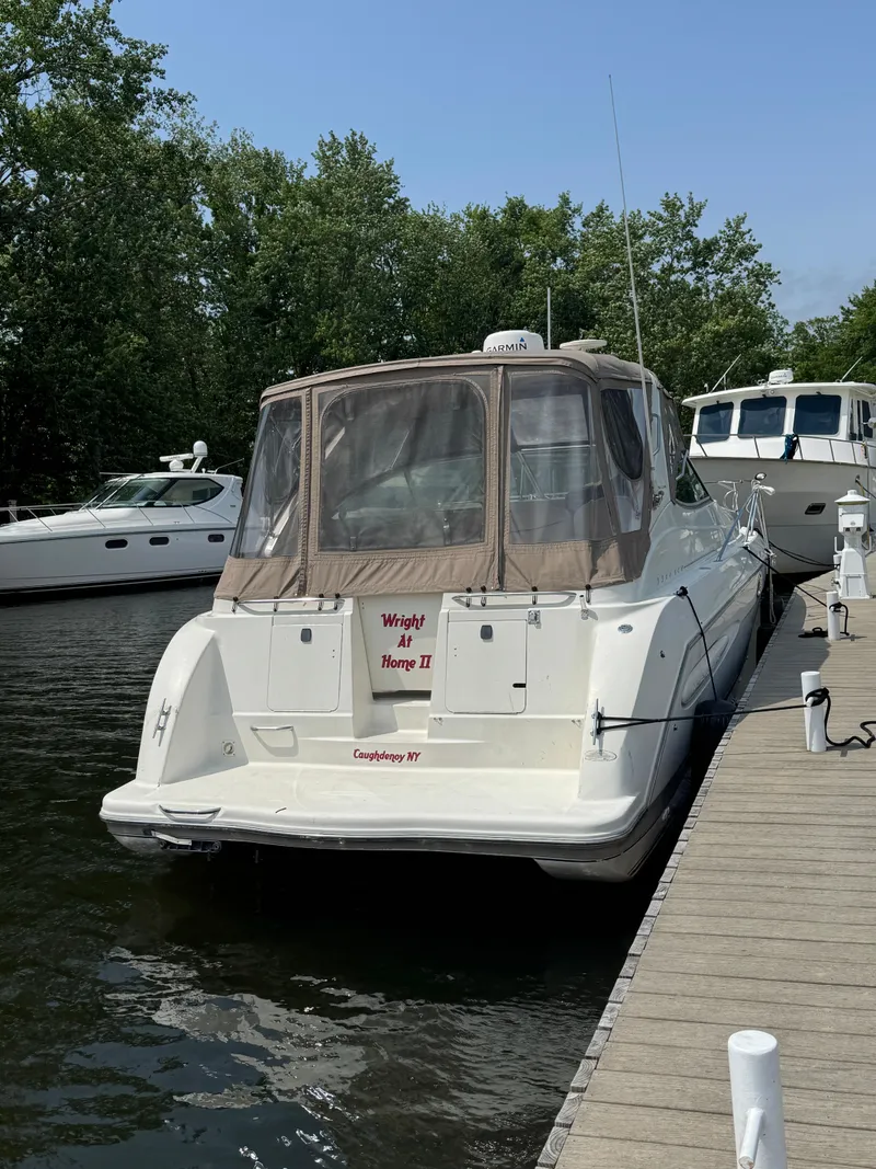 Slide: The Image of 2001 Maxum 3300 SCR yacht docked, featuring a beige canopy and white hull. - 5