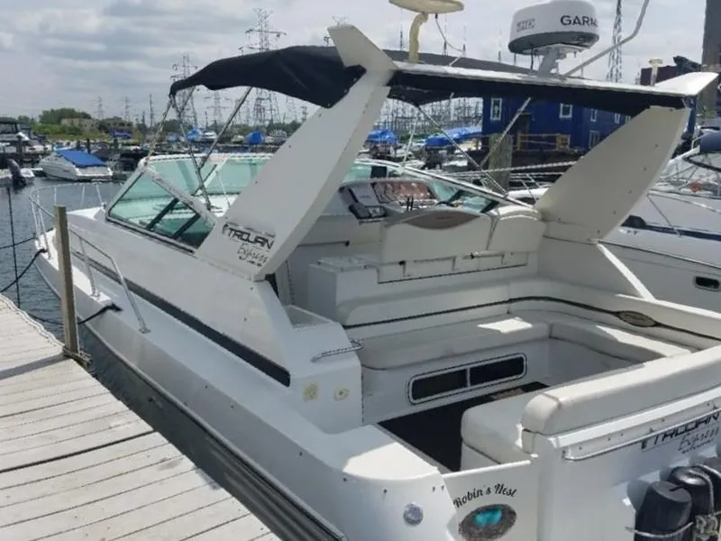 Slide: The Image of 1999 Trojan 40 Express yacht docked at marina, featuring spacious seating and sleek design. - 1