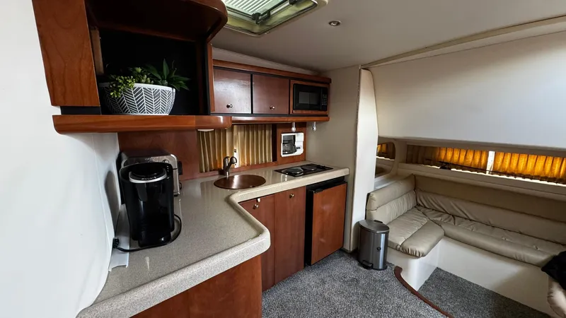 Slide: The Image of Interior of a 1999 Trojan 40 Express yacht with kitchenette and seating area. - 10