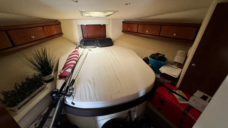 Slide: The Image of 1999 Trojan 40 Express cabin interior with bed, fishing rods, and storage cabinets. - 15